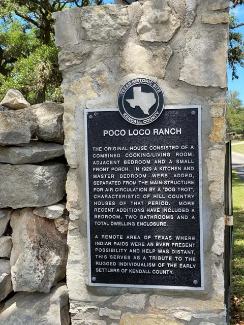 The historic marker mounted on the stone gate pillar at Poco Loco Ranch